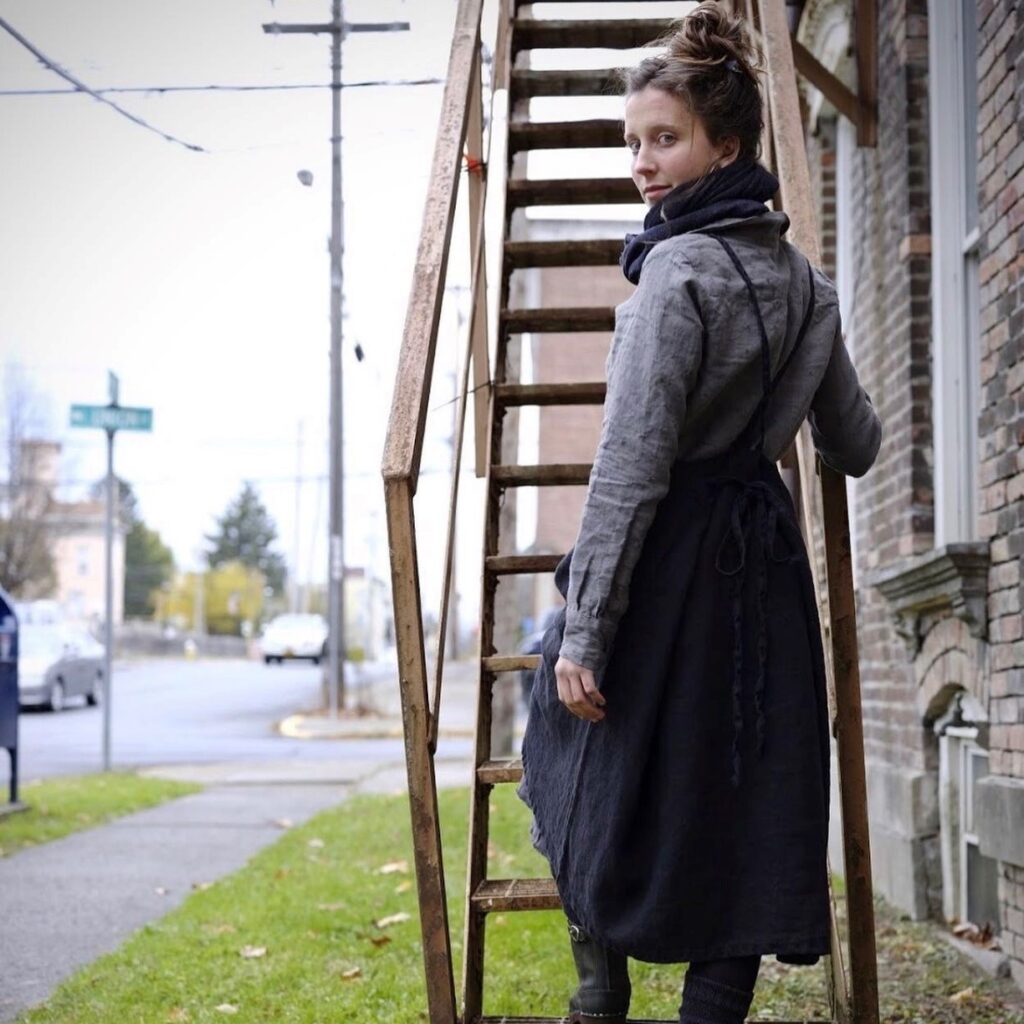 woman showing the back of a navy blue apron dress