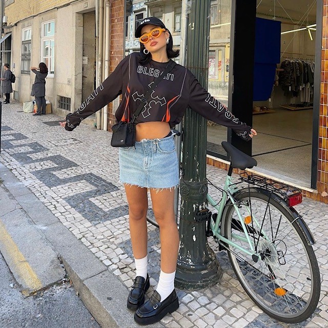 girl in denim micro mini skirt with sweatshirt and baseball cap