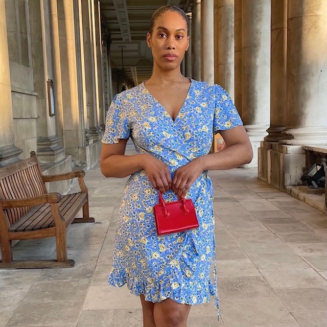 woman in light blue and yellow ditsy floral dress with mini red handbag