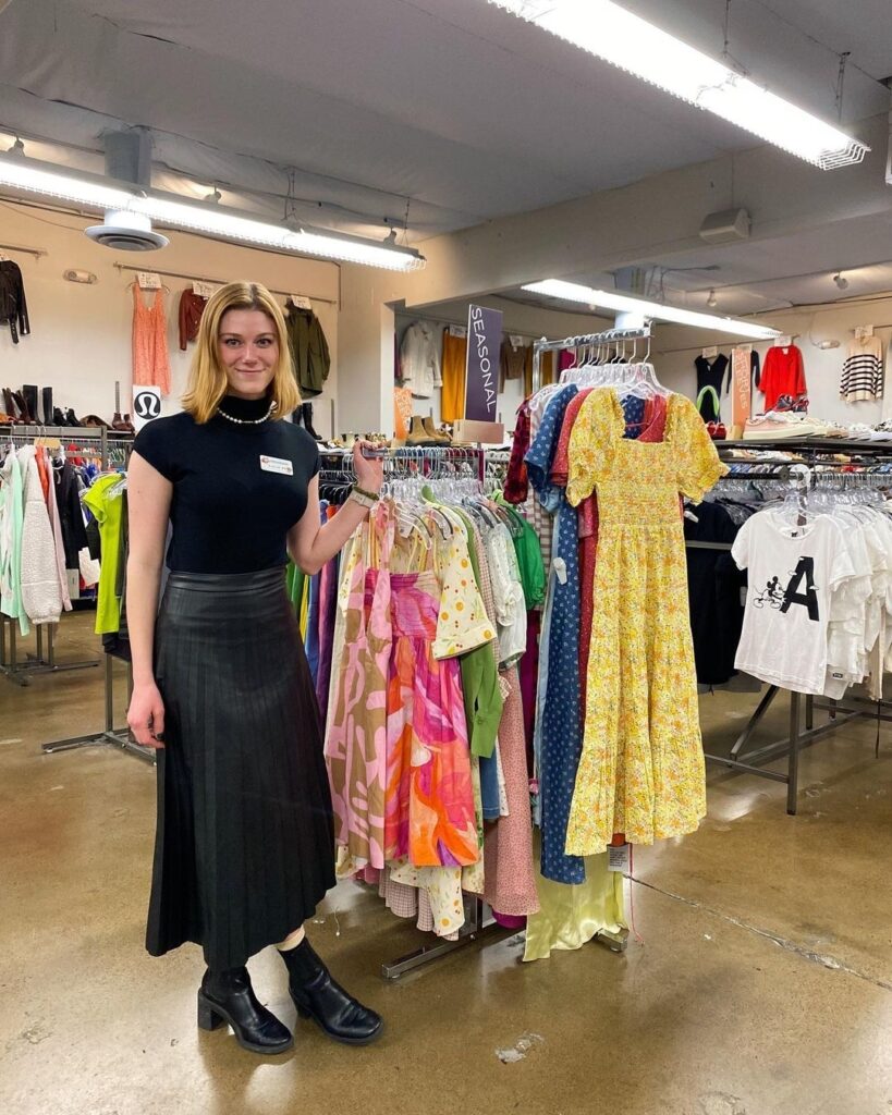 fashion employee standing next to a clothing rack