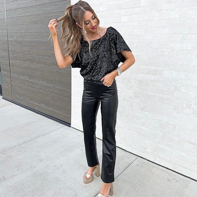 woman wearing a sequin top with leather pants and gold metallic platform heels