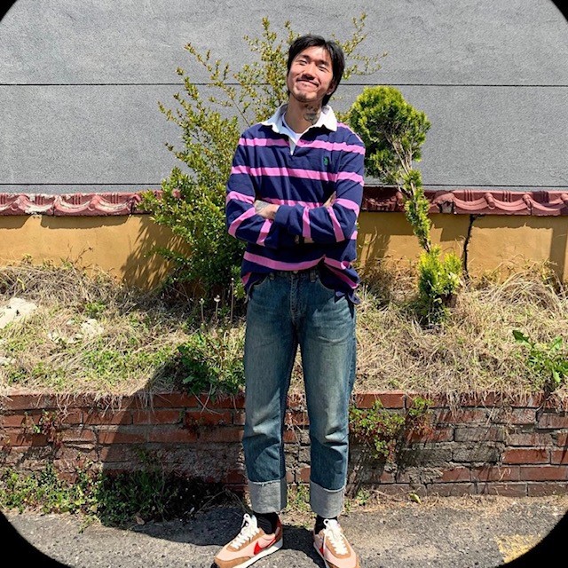 man wearing a purple rugby shirt with cuffed jeans