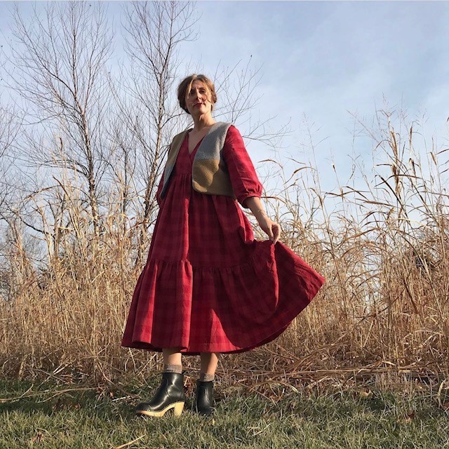 woman in red dress with black booties and a tan fleece vest