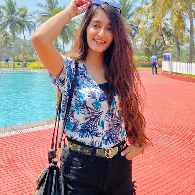 woman in a blue floral top with black shorts