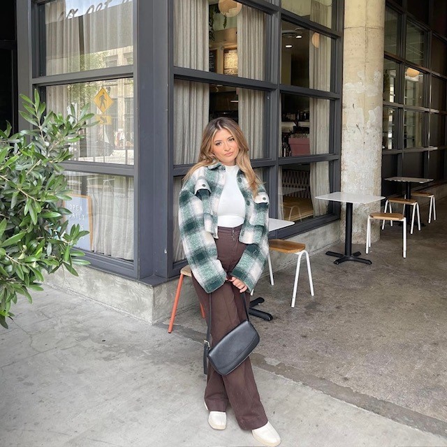 Woman with a jacket, white tee, and brown cargo pants