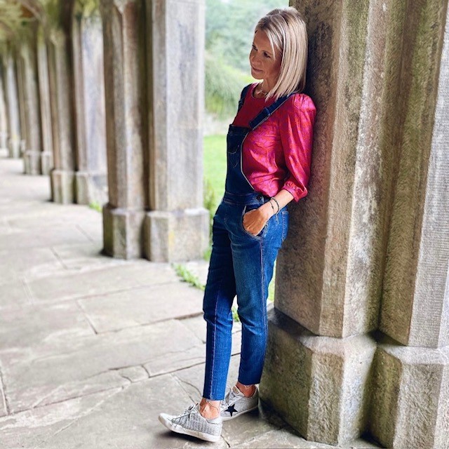 woman in overalls and red long-sleeve shirt