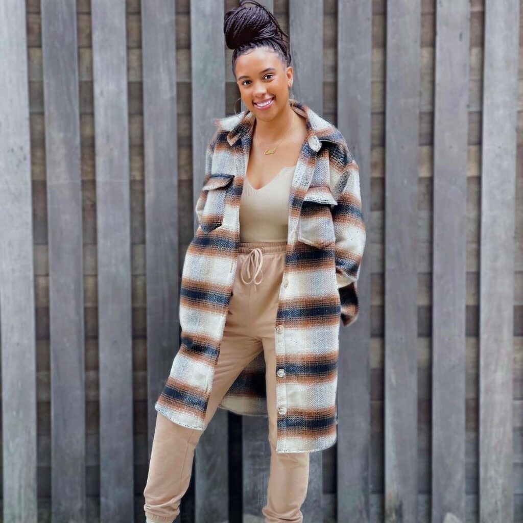 woman with long flannel jacket over beige tank top and sweatpants