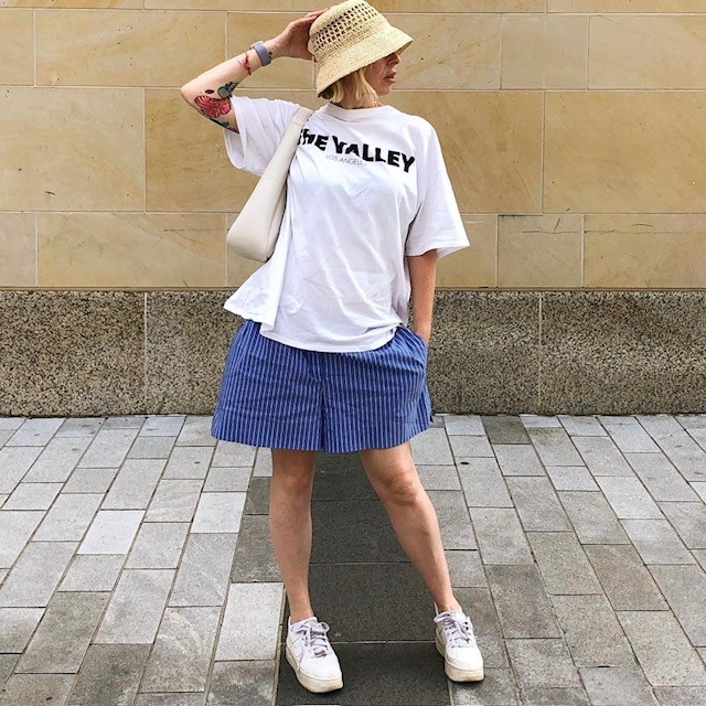 woman in large white t-shirt and baggy blue boxers