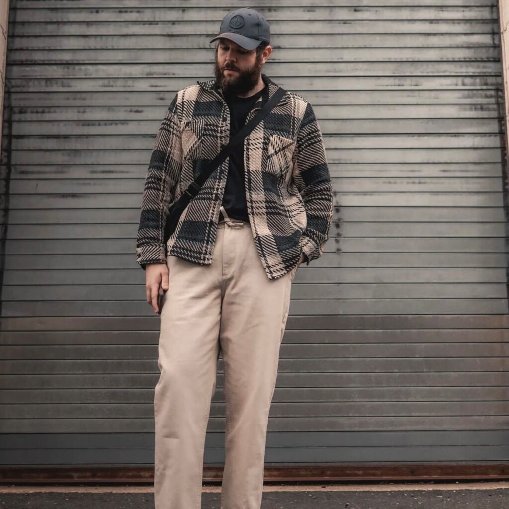 Man with jacket, black tee, and khaki pants