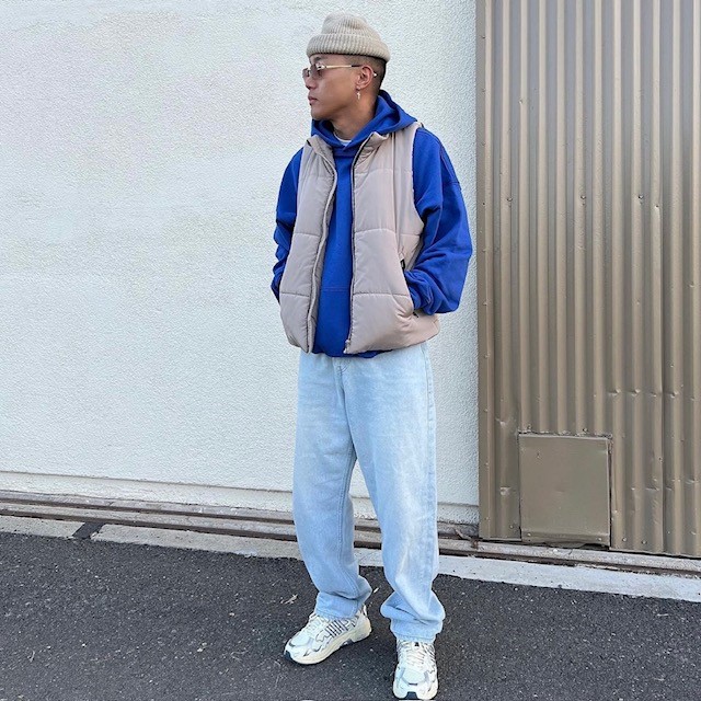 man wearing one over a blue sweatshirt and light wash jeans