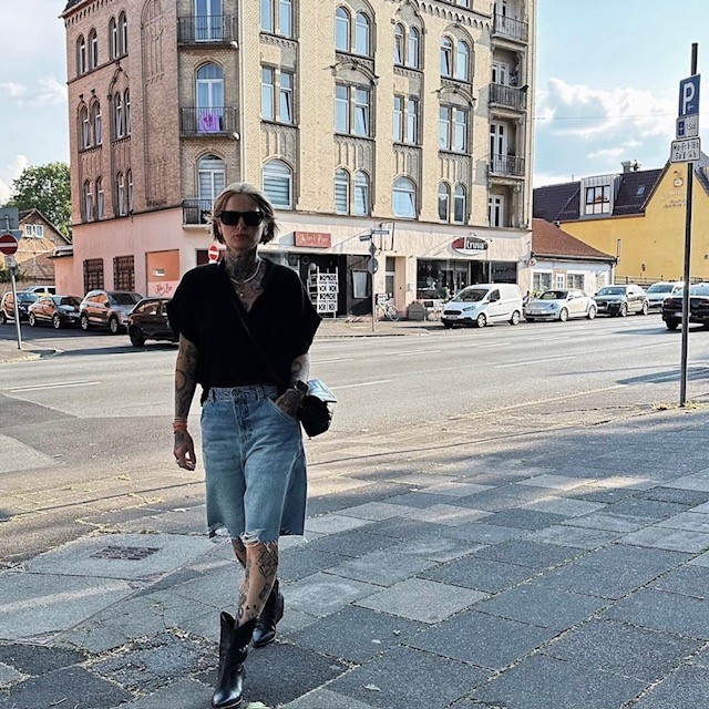 woman wearing black blouse and cutoff denim jeans with cowboy boots