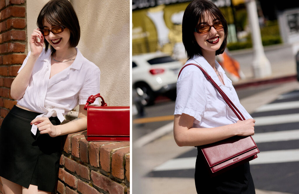 Cate wearing a white button up shirt and black skirt holding a red purse