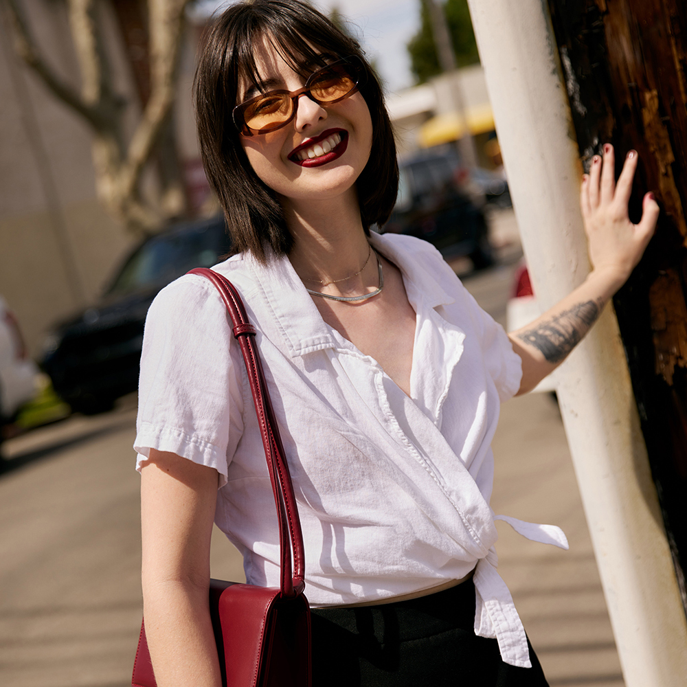 Cate wearing summer fashion leaning against a telephone pole