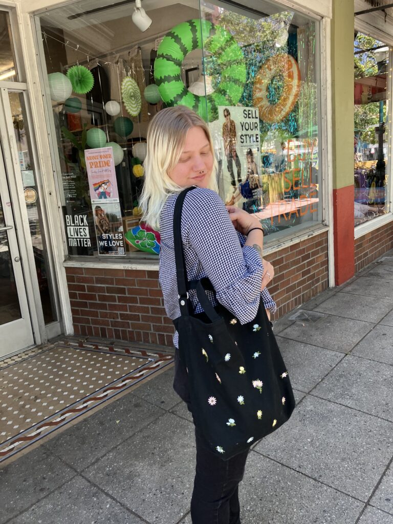 woman showing off black beach bag