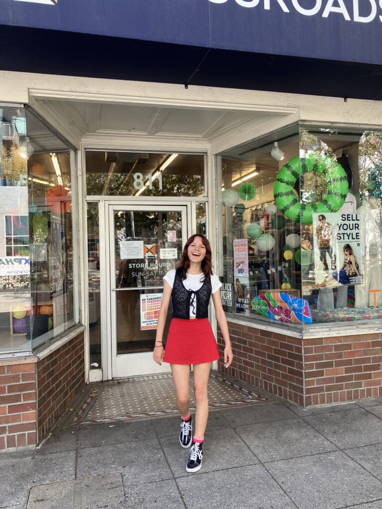 woman in summer trends of white tee with crochet vest and red skater skirt