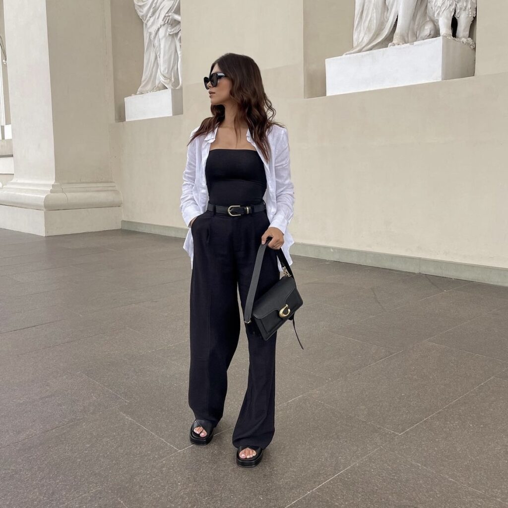 photo of person wearing black pants, a black tube top, and a white blouse