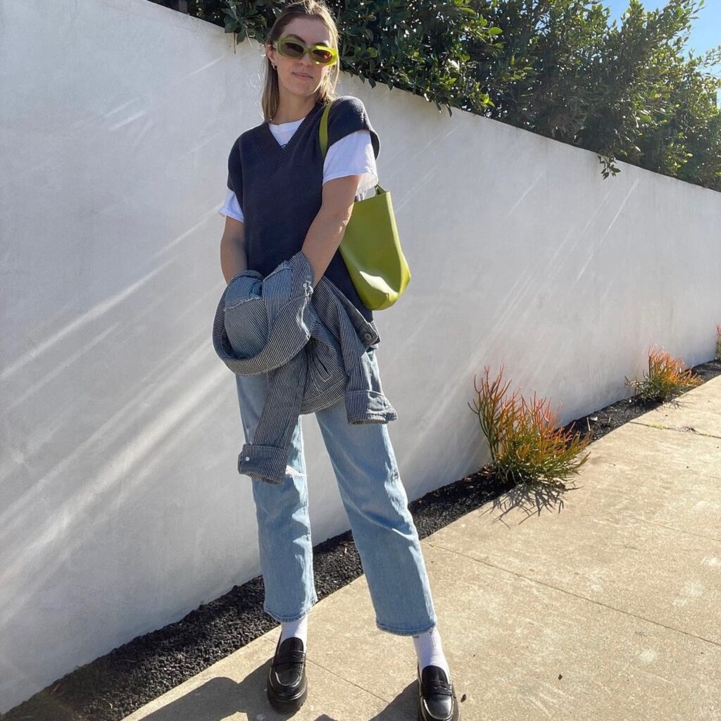 photo of person in gray vest with white tee and jeans