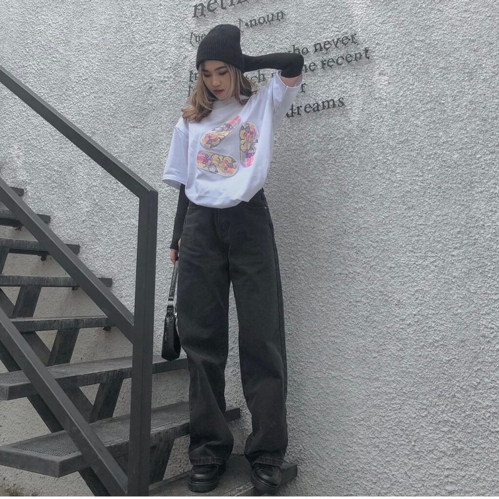 woman wearing a t-shirt and baggy black jeans