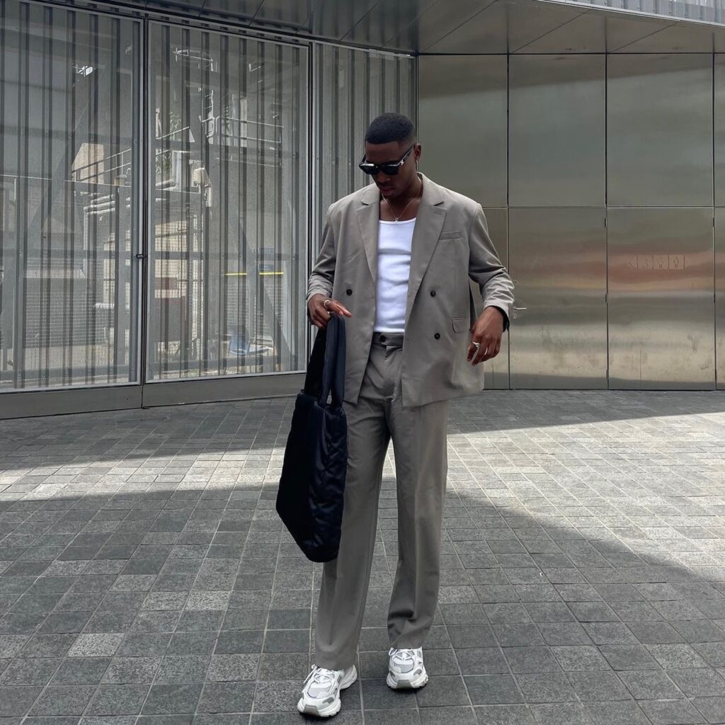 man wearing tan set with white t-shirt and black tote