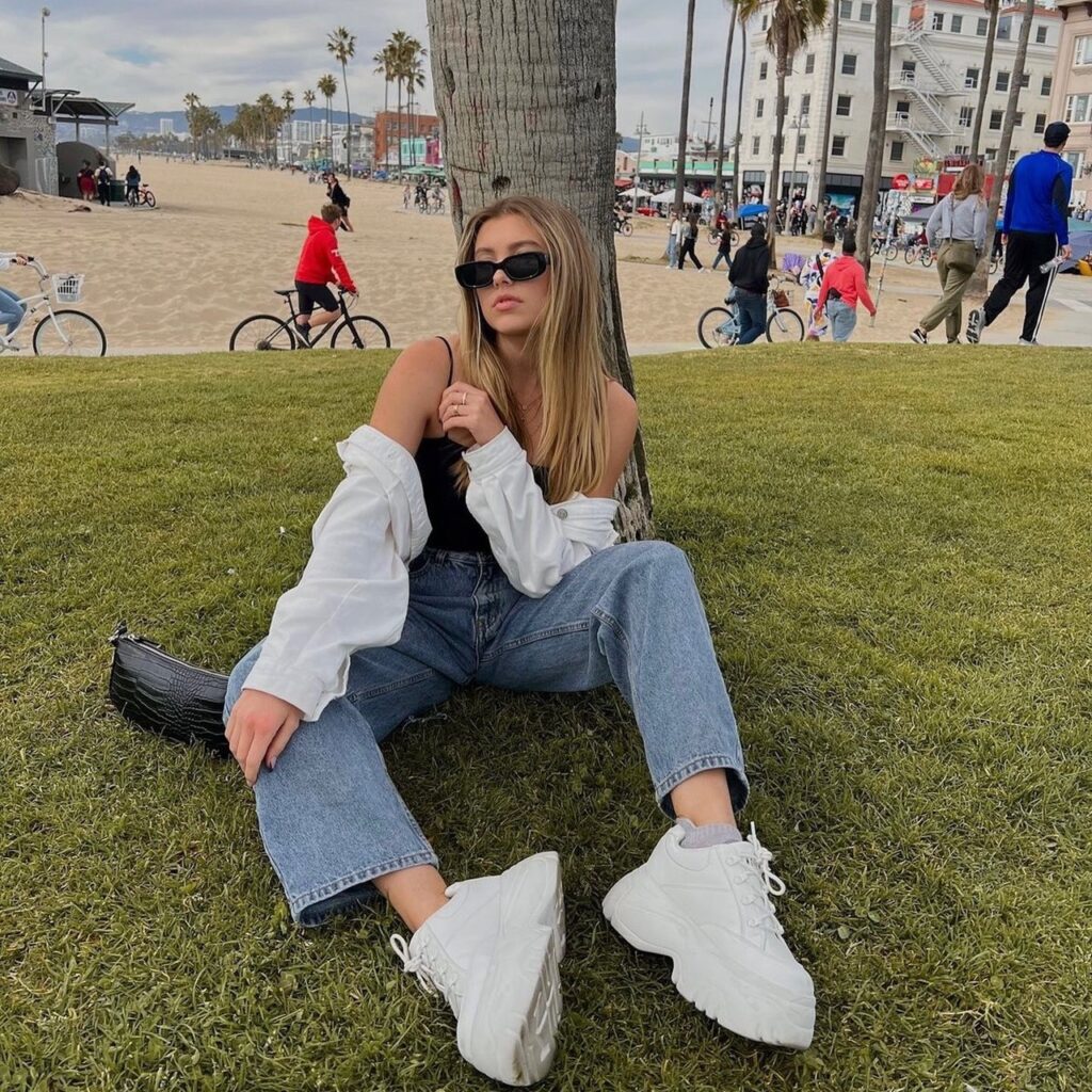 woman wearing white platform shoes with jeans and tank top