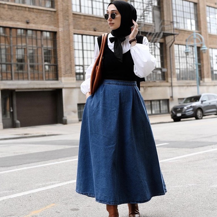 photo of person in a skirt and blouse with vest