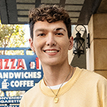 model smiling wearing a yellow sweater